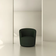 Modern dark green swivel armchair in a minimalist beige interior space